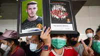 Penggemar Manchester United Football Club asal Thailand menyambut kedatangan skuad Setan Merah, Sabtu (9/7/2022) di bandara Bangkok, Thailand. (AFP/Manan Vatsyayana)