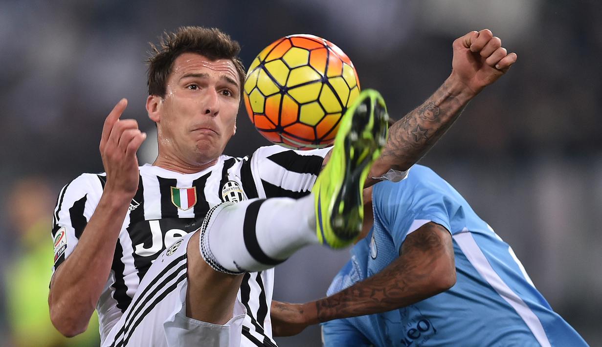 Pemain Juventus, Mario Mandzukic (kiri)  berebut bola dengan pemain Lazio, Ricardo Kishna pada lanjutan Liga Italia Serie A di Stadion Olimpico, Sabtu (5/12/2015) dini hari WIB.  (AFP Photo/Alberto Pizzoli)