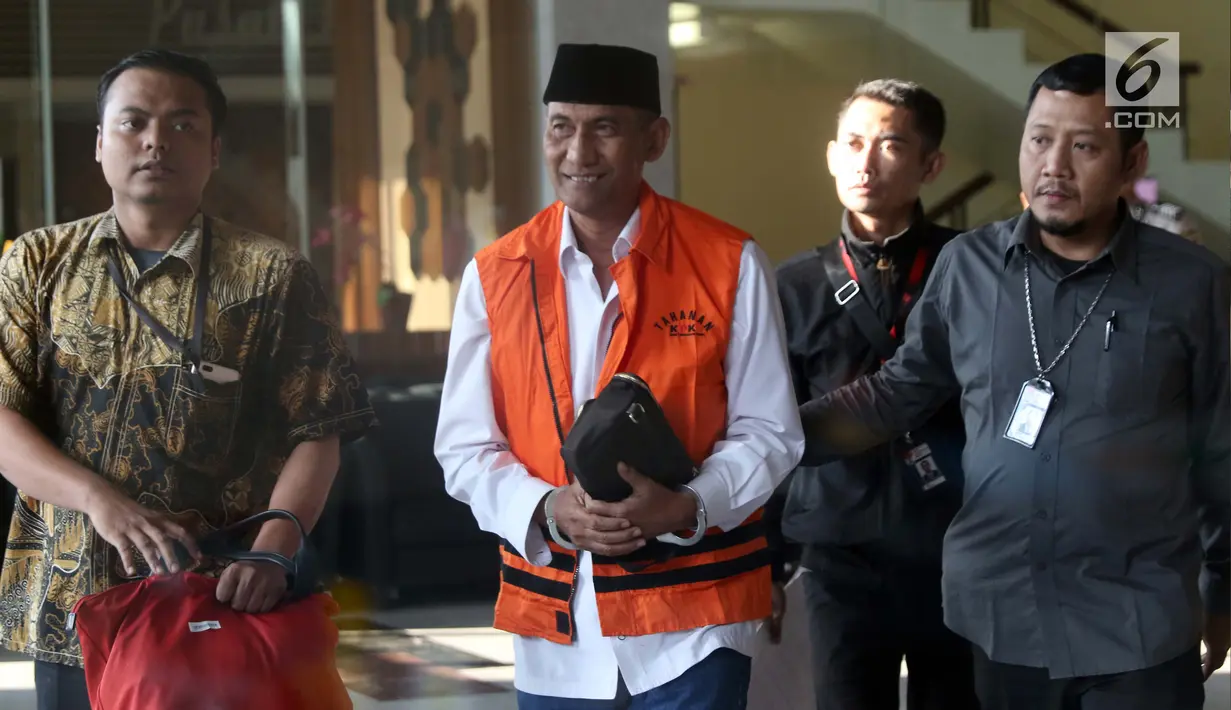 Bupati Kudus, Muhammad Tamzil (tengah) digiring petugas usai menjalani pemeriksaan terkait dugaan suap pengisian jabatan perangkat daerah di lingkungan Pemkab Kudus, Gedung KPK Jakarta, Sabtu (27/7/2019). KPK menyita barang bukti uang sebesar Rp170 juta. (Liputan6.com/Helmi Fithriansyah)
