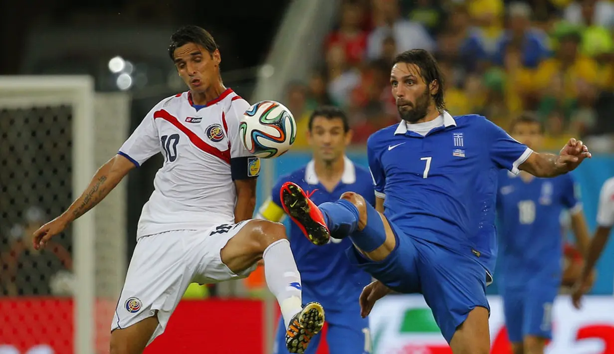Pemain depan Timnas Kosta Rika, Bryan Ruiz (kiri), berebut bola dengan Giorgios Samaras (Yunani) saat berlaga di 16 besar Piala Dunia 2014 di Stadion Pernambuco, Recife, (30/6/2014). (REUTERS/Brian Snyder)