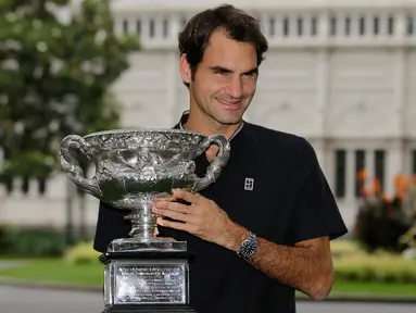 Petenis asal Swiss Roger Federer berpose dengan piala Australian Open 2017 di Carlton Gardens di Melbourne, Australia (30/1). Federer mengalahkan Nadal dengan skor -4 3-6 6-1 3-6 6-3. (AP Photo / Aaron Favila)