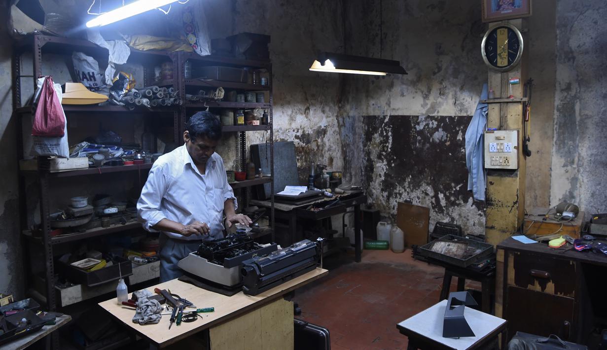Teknisi mesin tik, Anand Savarkar memperbaiki mesin tik di bengkelnya di Mumbai, India (6/7). Mesin tik di India kini mulai ditinggalkan, karena terasa sudah ketinggalan zaman di era komputer dan Internet. (AFP Photo/Indranil Mukherjee)