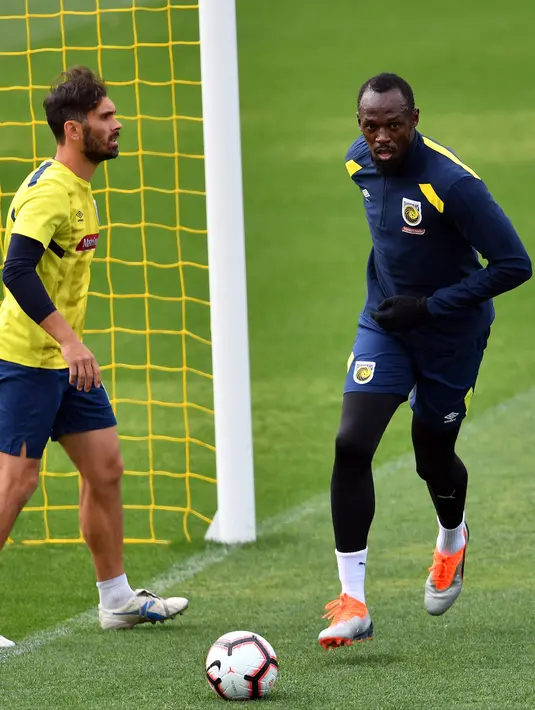 Usain Bolt menggiring bola saat berlatih di Central Coast Stadium, Gosford, Australia, (21/8). Pelari asal Jamaika ini akan bermain menjadi pesepak bola melawan klub amatir lokal pada Jumat (31/8/2018). (AFP Photo/Saeed Khan)