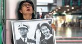 Seorang pelayat Thailand, Kanjana Malaithong, memegang potret Ratu Thailand yang telah wafat, Sirikit Kitiyakara, dan Raja Thailand Bhumibol Adulyadej, sambil menangis di Rumah Sakit Chulalongkorn di Bangkok pada 25 Oktober 2025. (Chanakarn Laosarakham/AFP)