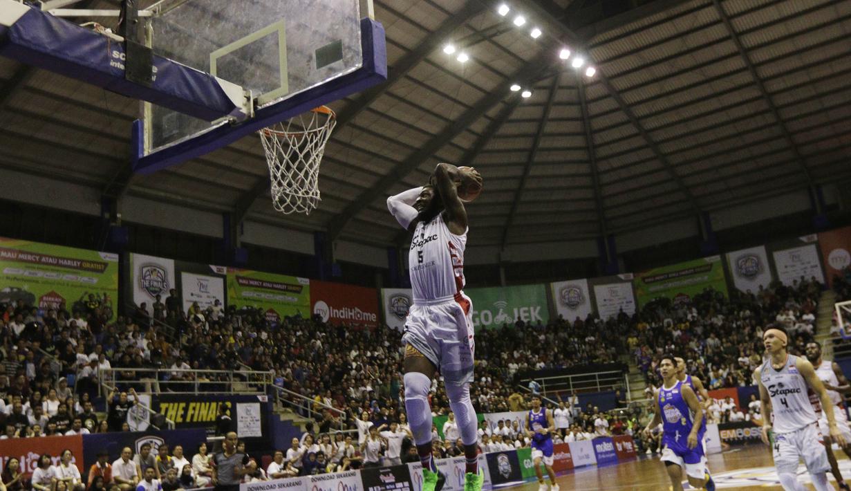 Pebasket Stapac Jakarta, Savon Goodman, memasukkan bola saat melawan Satria Muda Jakarta pada laga final IBL 2019  di C-Tra Arena, Bandung, Sabtu (23/3). Savon Goodman terpilih menjadi pemain terbaik IBL 2019. (Bola.com/M Iqbal Ichsan)