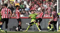 Bek Brentford, Ben Mee (kedua kiri) saat mencetak gol ke gawang Manchester United pada pertandingan lanjutan Liga Inggris di Gtech Community Stadium di London, Sabtu (13/8/2022). Brentford menang telak atas MU 4-0. (AFP Photo / Ian Kington)