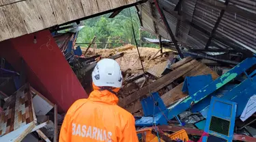 Foto selebaran yang diambil dan dirilis pada 7 Maret 2023 oleh kantor Kementerian Komunikasi dan Informatika Natuna ini menunjukkan tim penyelamat sedang memeriksa kerusakan akibat tanah longsor di Natuna, Kepulauan Riau (Kepri).  Kapolres Natuna Ajun Komisaris Besar Nanang Budi Santosa mengatakan, saat ini masih ada sekitar 47 orang dinyatakan hilang dan 27 rumah tertimbun material tanah longsor. (HO / Natuna ministry of communication / AFP)