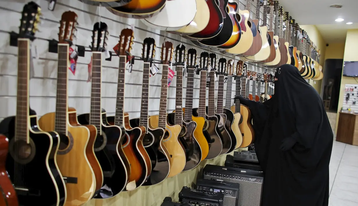 Gisele Marie melihat gitar di sebuah toko yang menjual alat musik di Sao Paulo, Brasil (13/8/2015). Marie merupakan cucu dari kakek beragama Katolik Jerman, ia masuk Islam setelah ayahnya meninggal pada tahun 2009. (REUTERS/Nacho Doce)