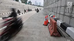 Kendaraan melintas di dekat penutup lubang saluran air yang kembali hilang di Underpass Mampang-Kuningan, Jakarta, Kamis (23/8). Dua buah steel grating atau besi penutup saluran air hilang dicuri orang tak dikenal. (Merdeka.com/Iqbal S. Nugroho)