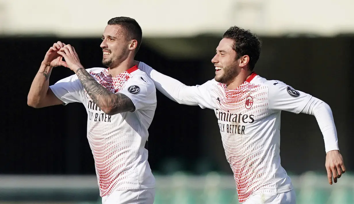 Pemain AC Milan, Rade Krunic, melakukan selebrasi bersama Davide Calabria usai mencetak gol ke gawang Verona pada laga Liga Italia di Stadion Bentegodi, Minggu (7/3/2021). AC Milan menang dengan skor 2-0. (Spada/LaPresse via AP)
