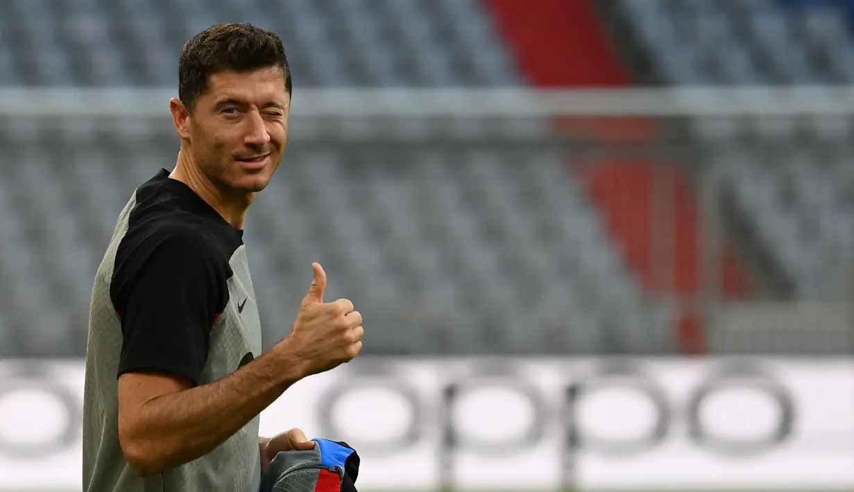 Penyerang Barcelona, Robert Lewandowski mengacungkan jempol saat ia tiba untuk sesi latihan di Munich, Jerman selatan (12/9/2022). Lewandowski yang pernah berseragam Bayern selama delapan musim akan kembali ke Allianz Arena dengan jersey warna berbeda. Lewandowski berpotensi menjebol gawang Bayern Muenchen. (AFP/Christof Stache)