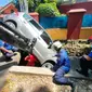 Petugas Damkar mengevakuasi mobil yang terpersok ke selokan di Jalan Pembaharuan, Kelapa Dua Wetan, Ciracas, Jakarta Timur. (Sudin Gulkarmat Jaktim)