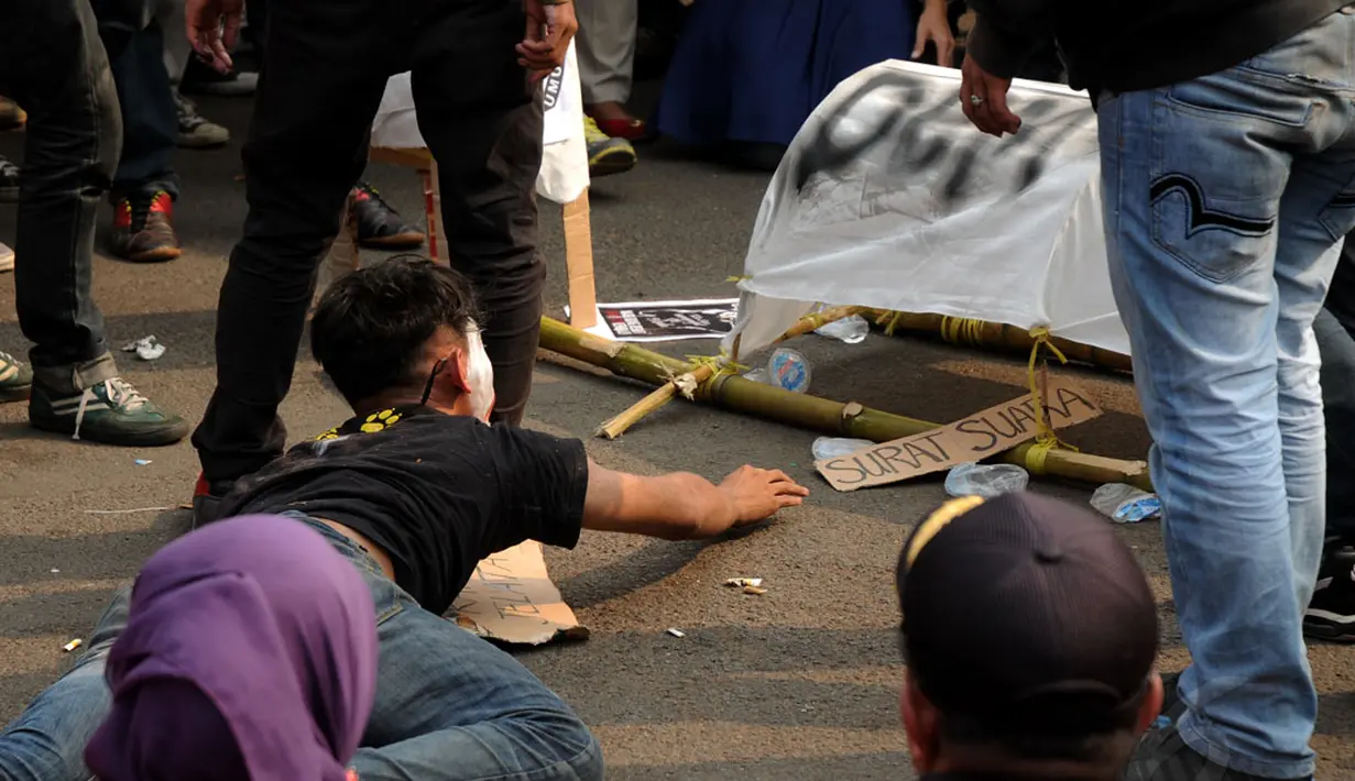 Sejumlah mahasiswa melakukan aksi teatrikal yang menggambarkan perjuangan rakyat merebut kembali hak politik dalam Pilkada, Jakarta, (14/10/2014). (Liputan6.com/Helmi Fithriansyah)