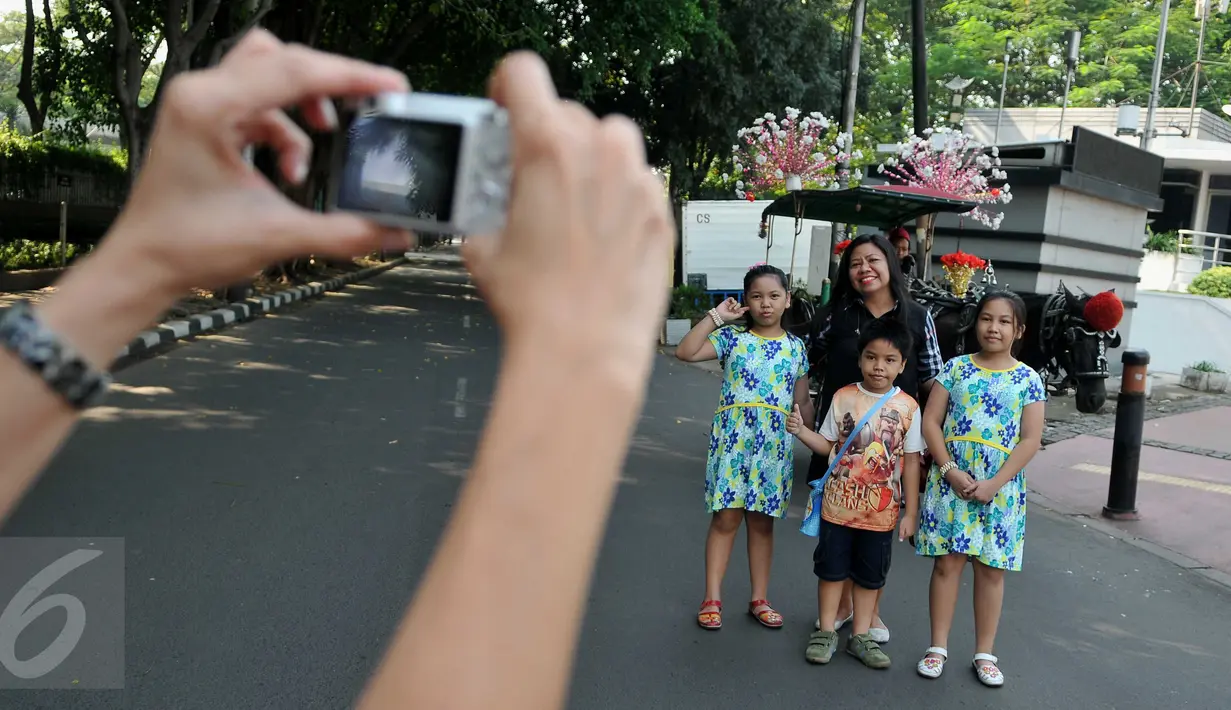Warga berfoto bersama delman di Kawasan Bundaran HI ketika pelaksanaan CFD, Jakarta, (26/6). Pelarangan itu untuk menegakkan aturan pemprov DKI Jakarta yang melarang operasional delman melintasi sejumlah protokol di Jakarta. (Liputan6.com/Gempur M Surya)