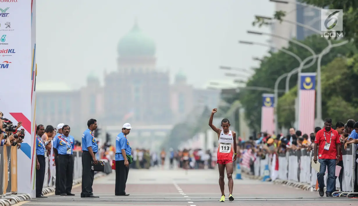  Pelari Indonesia Agus Prayogo saat melewati garis finis trek maraton SEA Games XXIX di Putra Jaya, Kuala Lumpur, Malaysia, Sabtu (19/8).  Agus berhasil meraih medali perak nomor lari marathon cabang atletik. (Liputan6.com/Faizal Fanani)