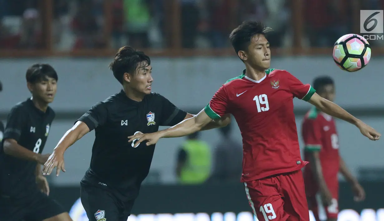 Pemain depan Timnas Indonesia U-19, Hanis Saghara Putra (kanan) berebut bola dengan pemain Thailand U-19 pada laga persahabatan di Stadion Wibawa Mukti, Cikarang, Jawa Barat, Minggu (8/10). Indonesia menang 3-0. (Liputan6.com/Helmi Fithriansyah)