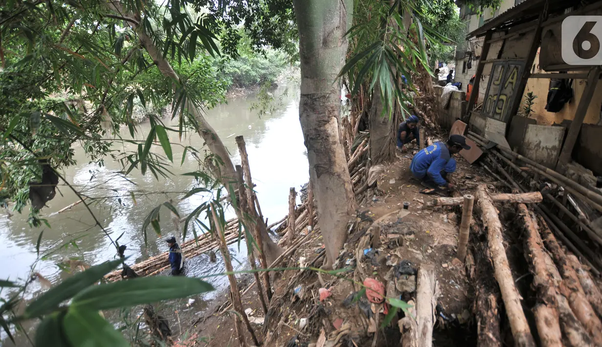 Petugas Suku Dinas Sumber Daya Air Jakarta Selatan menyelesaikan pembangunan tanggul di bantaran Sungai Ciliwung, Rawajati, Pancoran, Jakarta, Senin (11/11/2019). Tanggul tersebut diharapkan bisa membentengi permukiman warga dari luapan Sungai Ciliwung saat musim hujan. (merdeka.com/Iqbal Nugroho)