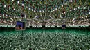 Seorang pengunjung berfoto dengan smartphone-nya di ruang cermin heksagonal berjudul 'Kusama's Peep Show or Endless Love Show' (1966) karya seniman Jepang Yayoi Kusama dalam pameran Yayoi Kusama: A Retrospective di Atrium Martin Gropius Bau, Berlin, Jerman, Selasa (19/5/2021). (John MACDOUGALL/AFP)