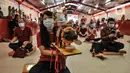 Warga keturunan Tionghoas membawa patung simbol kerbau logam yang merupakan shio Tahun Baru Imlek 2572 di klenteng kawasan Petak Sembilan, Glodok, Jakarta, Kamis (11/2/2021). Pembatasan waktu sembahyang malam Imlek kali ini sebagai langkah mencegah penyebaran COVID-19. (merdeka.com/Iqbal S. Nugroho)