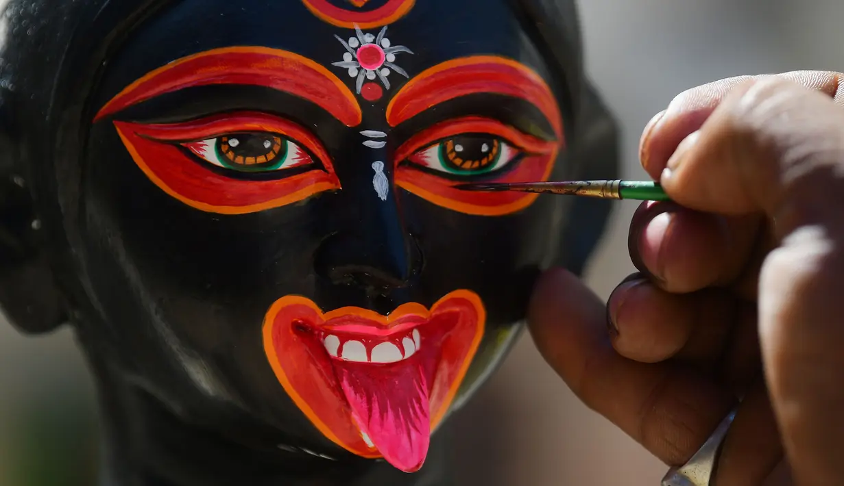 Seorang pemahat mengecat patung Dewi Kali menjelang festival Diwali di Agartala, ibu kota Negara Bagian Tripura, India timur laut, pada 12 November 2020. (Xinhua/Stringer)