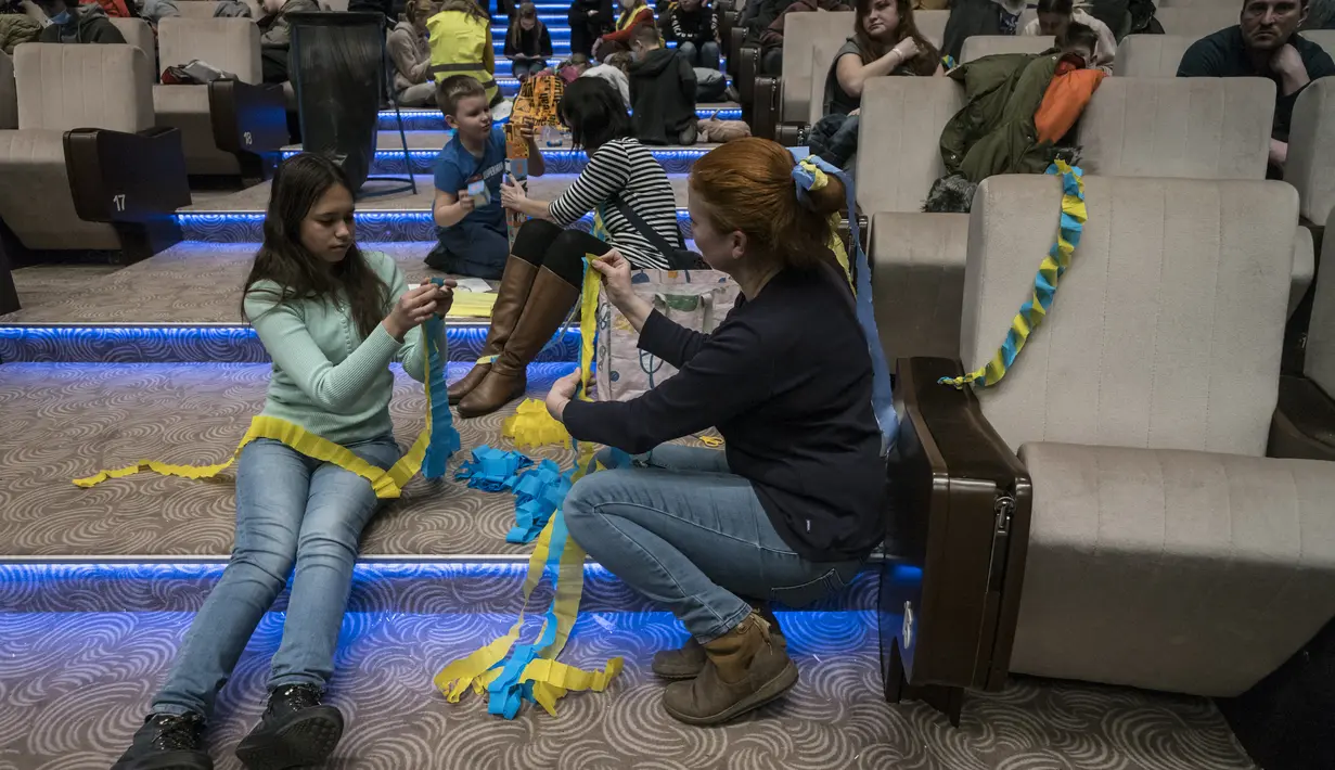 Relawan Ceko bermain dengan anak-anak pengungsi Ukraina di pusat bantuan regional di Pusat Kongres Praha di Pusat Kongres Praha di Praha, Republik Ceko (7/3/2022). Ceko merupakan salah satu dari 17 negara yang memberi bantuan langsung kepada Ukraina untuk melawan Rusia. (AFP/Michal Cizek)