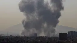 Dua kepulan asap tebal terlihat di atas pusat dan timur ibu kota Iran, Teheran. Tampak dalam foto, kepulan asap membubung setelah ledakan yang dilaporkan terjadi di Teheran, Iran, pada 28 Februari 2026. (ATTA KENARE/AFP)