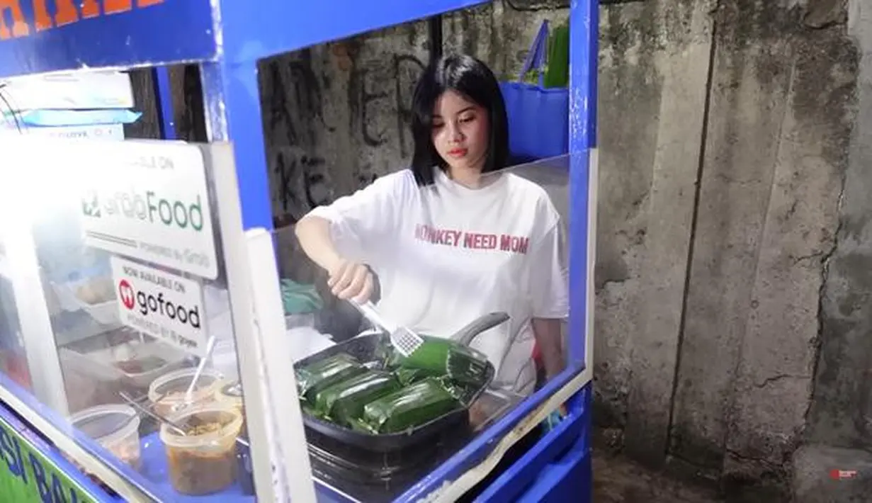 Melati Sesilia mantan member JKT48 namanya sempat ramai dibicarakan setelah kedapatan sedang berjualan nasi bakar di pinggir jalan. Momen tersebut diperlihatkan dalam sebuah konten video yang akhirnya viral. Sempat malu, Melati kini makin cekatan. Awalnya Melati mempekerjakan seseorang untuk menjalani bisnis kulinernya itu. Namun suatu saat tiba-tiba karyawannya mengundurkan diri. Kesibukan Melati ini membuatnya semakin dikagumi karena ia melakukannya demi membantu sang ibunda. (Liputan6.com/YouTube/Boengkoes)