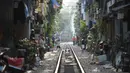 Gambar pada 21 Oktober 2018, rangkaian kereta api melewati jalur kereta yang melintasi kawasan permukiman di Hanoi, Vietnam. Rel yang selesai dibuat oleh Prancis pada tahun 1930an itu berada di tengah bangunan rumah dan pertokoan. (Nhac NGUYEN/AFP)