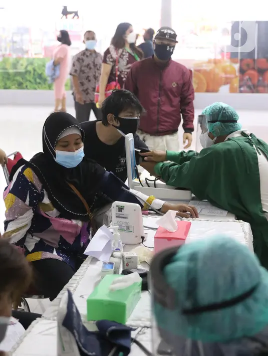 Petugas menscreening kesehatan peserta vasksinasi di sentra vaksin Tomang Tol Plaza, Tangerang, Sabtu (24/7/2021). Target pemerintah dalam pelaksanaan vaksinasi Covid-19 bertambah menjadi 208,2 juta orang yang sebelumnya 181,5 juta atau 70 persen dari total populasi. (Liputan6.com/Angga Yuniar)