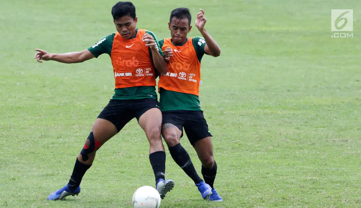 Pemain Timnas Indonesia U-22, Nurhidayat berebut bola dengan Dallen Doke saat berlatih di Stadion Madya, Jakarta, Kamis(24/1). Latihan ini digelar untuk menghadapi Piala AFF U-22. (Bola.com/Yoppy Renato)