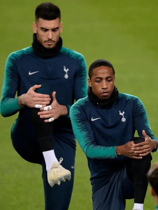 Bek Tottenham Hotspur, Kyle Walker-Peters (kanan) melakukan pemanasan selama latihan di stadion Camp Nou, Barcelona (10/12). Tottenham berada di posisi kedua grup B dengan poin tujuh sama seperti Inter Milan di posisi ketiga. (AFP Photo/Josep Lago)