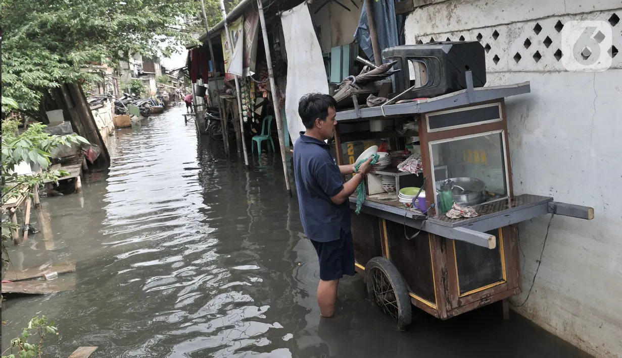 Aktivitas warga di tengah banjir yang masih merendam Kampung Rawa Indah, Jakarta Utara, Senin (24/2/2020). Kampung yang terletak di dua kelurahan, yakni Sukapura dan Pegangsaan Dua tersebut masih terendam banjir hingga sore ini dengan ketinggian air 30-50 cm. (merdeka.com/Iqbal S Nugroho)