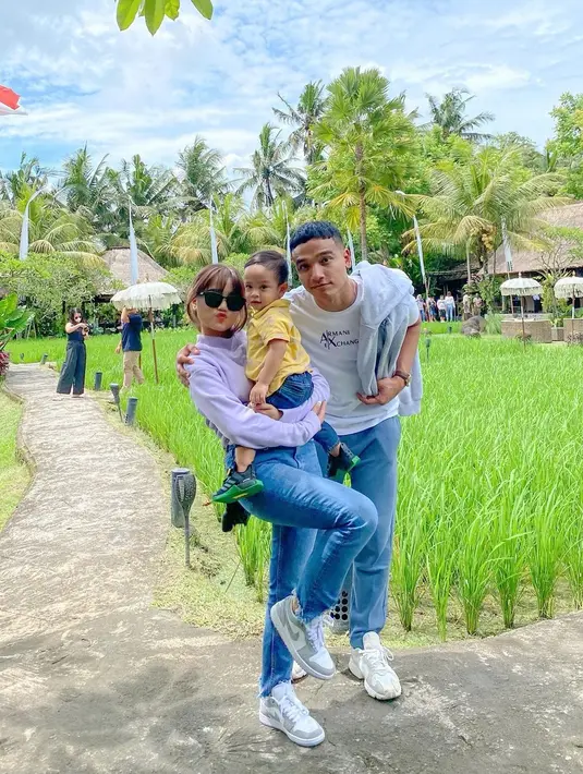 Terakhir adalah potret kompak Fuji dan Fadly bersama Gala. Fuji tampil mengenakan atasan turtleneck berwarna putih, dipadunya dengan celana jeans dan sneaker putih. Sedangkan Fadly tampil lebih simpel dengan kaus putih, celana jeans, dan sneakers putih. Foto: Instagram.