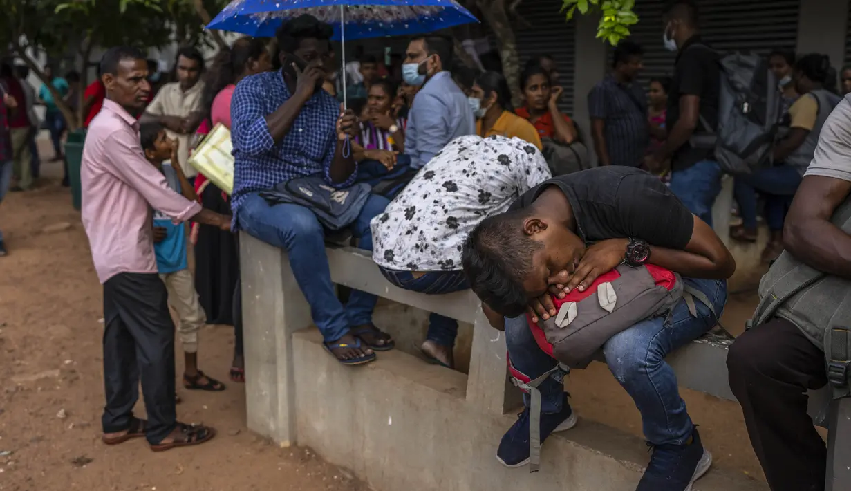 <p>Seorang pria tidur siang saat bersama dengan yang lain menunggu dalam antrean untuk mendapatkan paspor mereka di luar Departemen Imigrasi &amp; Emigrasi di Kolombo, Sri Lanka, Senin (18/7/2022). Negara kepulauan Samudra Hindia itu dilanda krisis ekonomi yang belum pernah terjadi sebelumnya yang telah memicu ketidakpastian politik. (AP Photo/Rafiq Maqbool)</p>