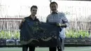 Dani Pedrosa menerima kain batik dari Menteri Pemuda dan Olah Raga Imam Nahrowi di Lapangan Futsal Kuningan Village, Jakarta, Sabtu (13/2/2016). (Bola.com/Nicklas Hanoatubun)