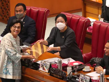 Menteri Keuangan Sri Mulyani (kiri) menyerahkan berkas keterangan pemerintah tentang pertanggung jawaban pelaksanaan APBN 2021 kepada Ketua DPR RI Puan Maharani dalam rapat paripurna ke-26 masa persidangan V tahun 2021-2022 di Kompleks Parlemen, Senayan, Jakarta, Kamis (30/6/2022). (Liputan6.com/Angga Yuniar)