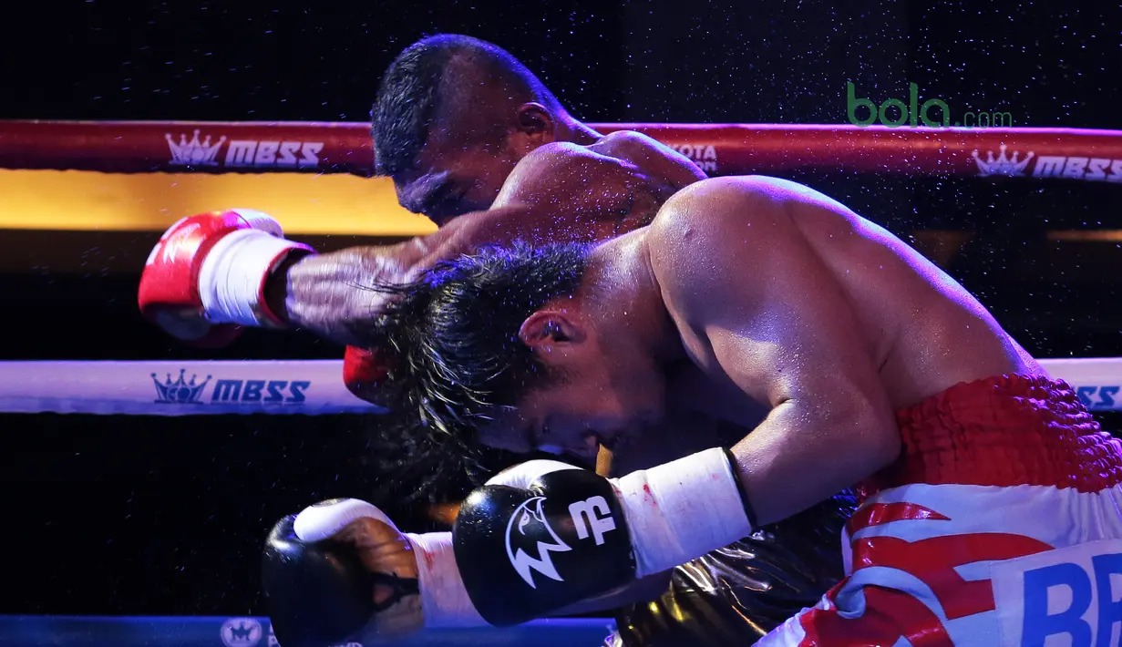 Jansen Marapu (kiri) melepaskan pukulan ke arah petinju Thailand, Phuttiphong Rakoon pada kelas Lightweight Mahkota Boxing Super Series di Cilandak Town Square, Jakarta (10/3/2018). Jansen menang TKO pada ronde ke sembilan. (Bola.com/Nick Hanoatubun)