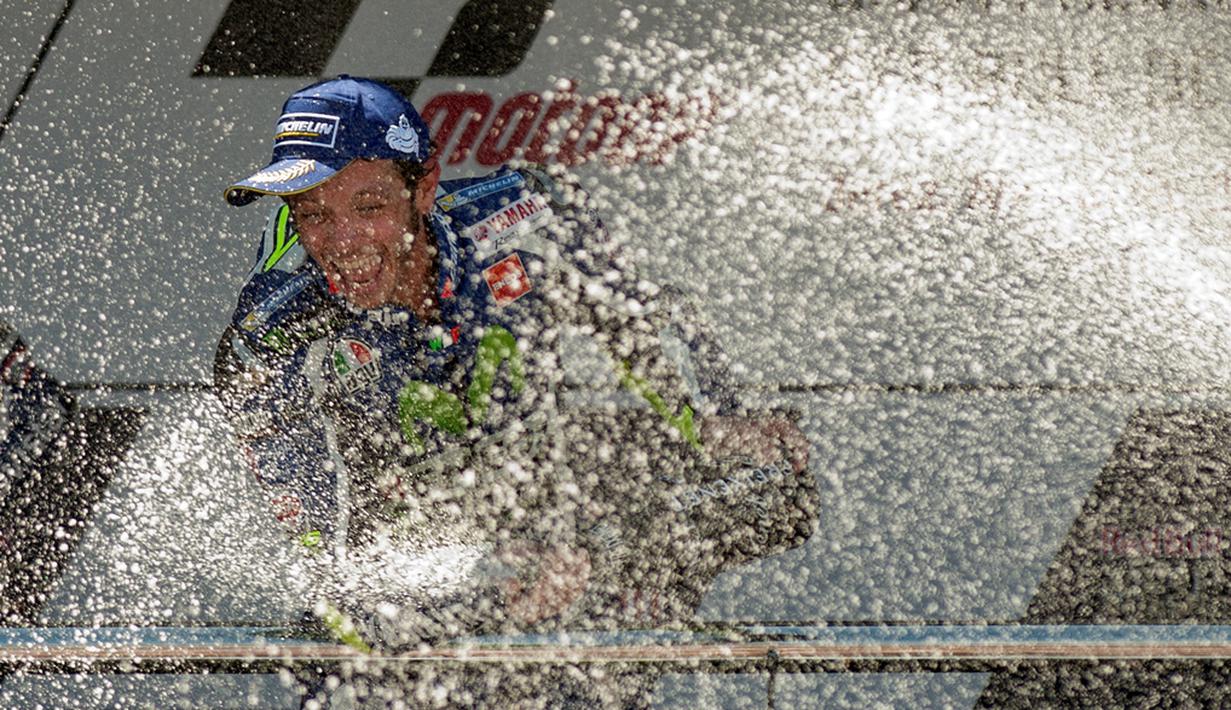 Juara MotoGP Jerez, Valentino Rossi, menyemprotkan sampanye di podium juara Sirkuit Jerez, Spanyol, Minggu (24/4/2016). (AFP/Jorge Guerrero)