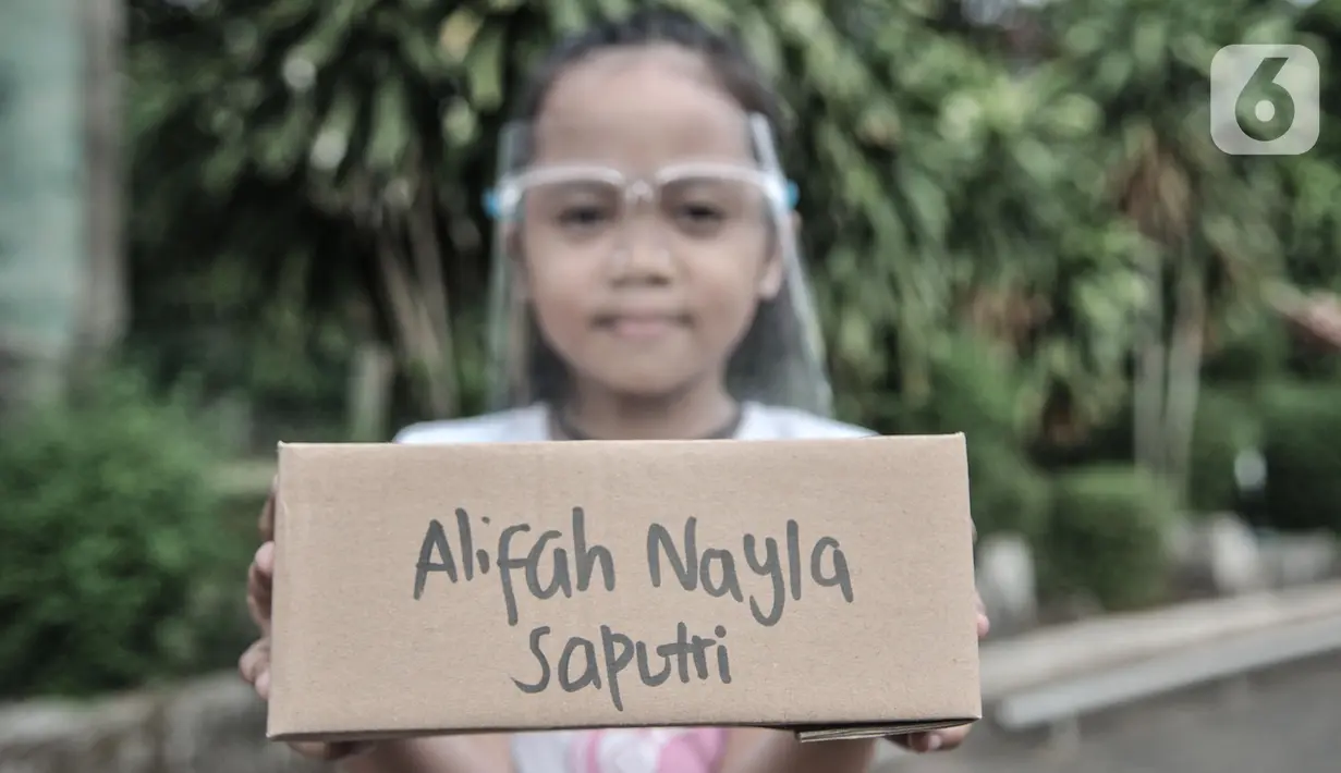 Seorang anak menunjukkan boks berisi ponsel yang diberikan komunitas #WartawanLintasMedia, Jakarta, Minggu (9/8/2020). 25 pelajar kurang mampu yang tergabung dalam Komunitas Rumah Belajar Pelangi Nusantara dan Perpustakaan Alternatif Jakarta menerima donasi ponsel. (merdeka.com/Iqbal S. Nugroho)