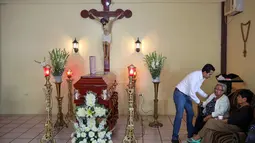 Keluarga dan kerabat menunggu jenazah Leobardo Vazquez, wartawan yang tewas di Gutierrez Zamora, Meksiko (22/3). Pada tahun 2017, sepuluh wartawan tewas terbunuh di negara Meksiko. (AP/Felix Marquez)