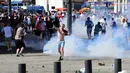 Fans Inggris melempar kembali gas air mata saat bentrokan antara fans Inggris dan polisi di kota Marseille, Prancis (11/6/2016). Bentrok terjadi menjelang pertandingan sepak bola Euro 2016 antara Inggris dan Rusia. (AFP Photo/Leon Neal)