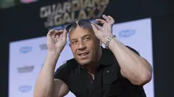 Pria berkepala plontos itu bergaya dengan mengangkat kecamatanya saat berpose di red carpet acara premiere "Guardians Of The Galaxy" di Hollywood, California, Selasa (22/7/14). (REUTERS/Mario Anzuoni)