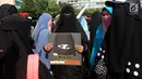 Anggota komunitas  Niqab Squad menunjukan poster saat melakukan Challenge kepada pengunjung Car Free Day (CFD) untuk mengenakan Niqab di kawasan Bundaran HI, Jakarta, Minggu (10/9). (Liputan6.com/Johan Tallo)