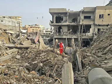 Seorang petugas penyelamat memeriksa puing-puing bangunan yang hancur di lokasi serangan Israel di wilayah Maarakeh, Lebanon selatan, dekat kota pesisir Tyre, pada Sabtu 4 April 2026. Militer Israel mengonfirmasi pada Jumat 3 April 2026 bahwa mereka telah menyerang lebih dari 3.500 target di seluruh Lebanon. (Kawnat HAJU/AFP)