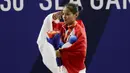 Lifter Windy Aisyah sikap hormat saat naik podium usai mendapatkan medali emas SEA Games 2019 cabang angkat besi nomor 49 kg di Stadion Rizal Memorial, Manila, Minggu (1/12). Dirinya meraih emas dengan total angkatan 104 kg. (Bola.com/M Iqbal Ichsan)