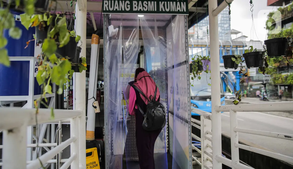 Calon penumpang memasuki bilik disinfektan di Halte Transjakarta Harmoni, Jakarta, Selasa (7/4/2020). Pemasangan bilik disinfektan tersebut sebagai upaya pencegahan penyebaran virus Corona COVID-19 di lingkungan Halte Transjakarta. (Liputan6.com/Faizal Fanani)