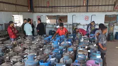 Pekerja Palestina mengisi tabung gas di stasiun pengisian resmi di kamp pengungsi Nuseirat, di bagian tengah Jalur Gaza, pada Senin 10 November 2025. Meski dalam jumlah terbatas, pasokan bahan bakar gas untuk memasak mulai didistribusikan ke warga Gaza. (Eyad Baba/AFP)