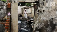 Warga melihat kondisi rumahnya yang terbakar di permukiman padat penduduk di Jalan Kemayoran Gempol, Kemayoran, Jakarta, Selasa (21/1/2025). (Liputan6.com/Herman Zakharia)