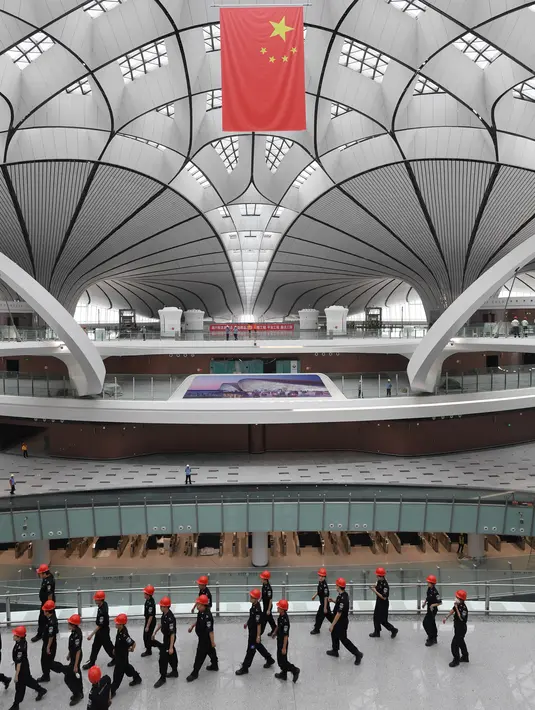 Pejabat keamanan melakukan tur Terminal Bandara Internasional Daxing Beijing, China, Selasa (9/7/2019). Bandara Internasional Daxing Beijing didesain oleh mendiang arsitek Zaha Hadid. (GREG BAKER/AFP)