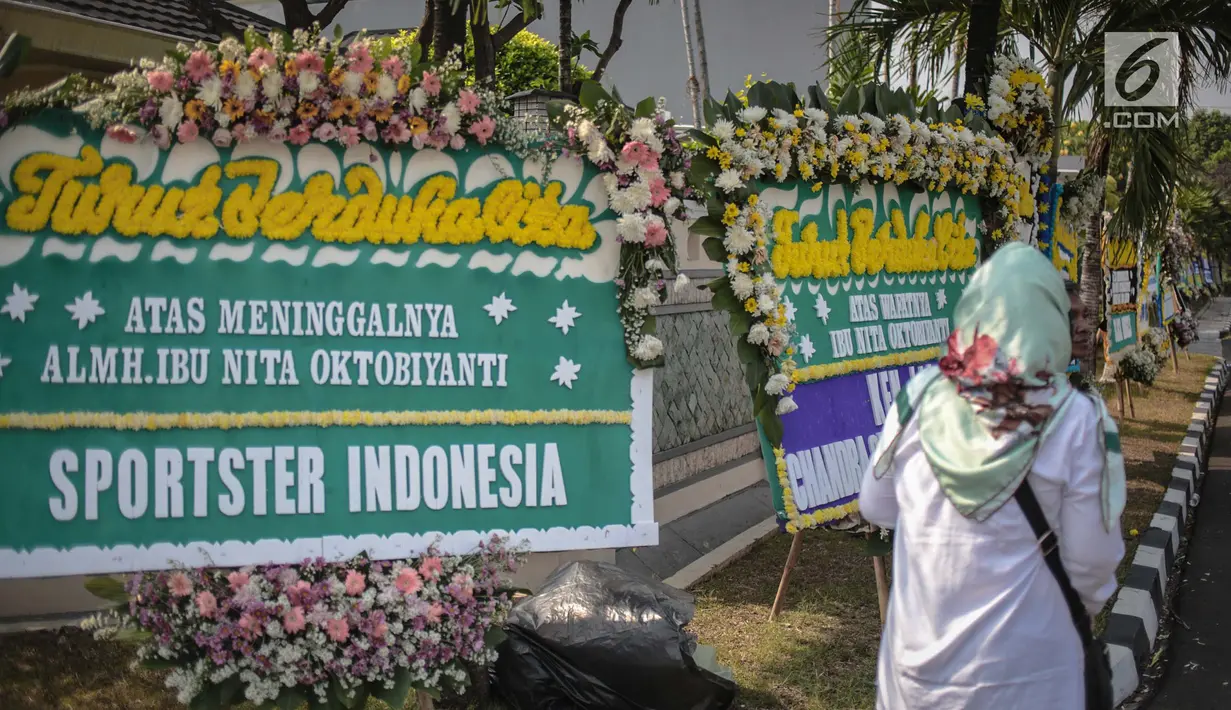 Warga melintas dekat karangan bunga atas meninggalnya istri Indro Warkop, Nita Octobijanthy yang terpajang di rumah duka kawasan Pulo Mas, Jakarta, Rabu (10/10). Istri Indro Warkop meninggal di usia 59 tahun akibat kanker. (Liputan6.com/Faizal Fanani)